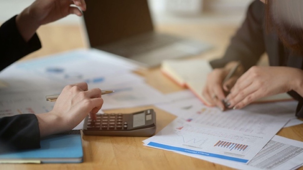 Dos personas con calculadora y presupuesto: compradores de flete auditando costos al 100%