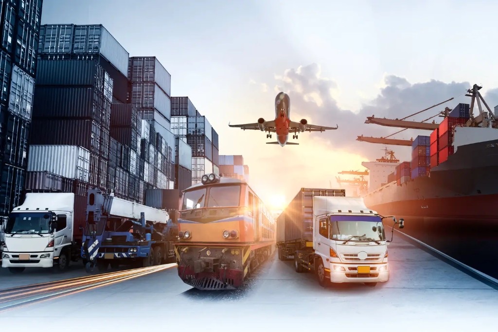 Multimodal logistics hub: cargo plane, freight train, semi-trucks, and container ship at sunset