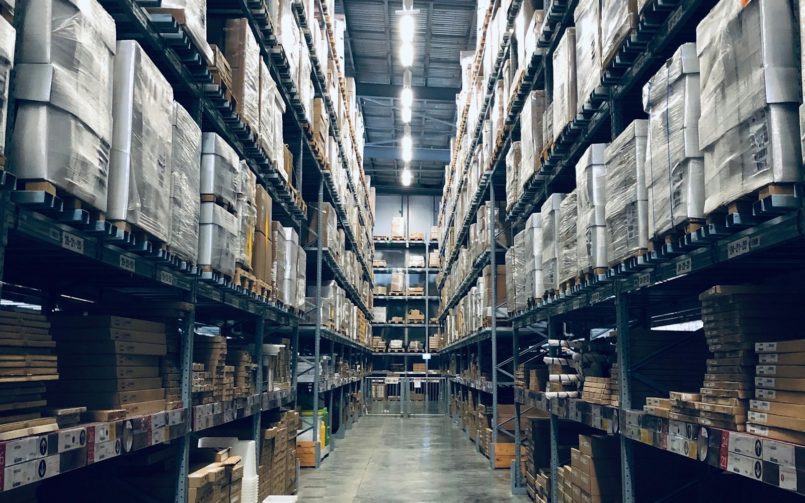 Pasillo de racks en CEDIS mexicano — TMS local Andlogistics/Neuroplus vs agentes OCL