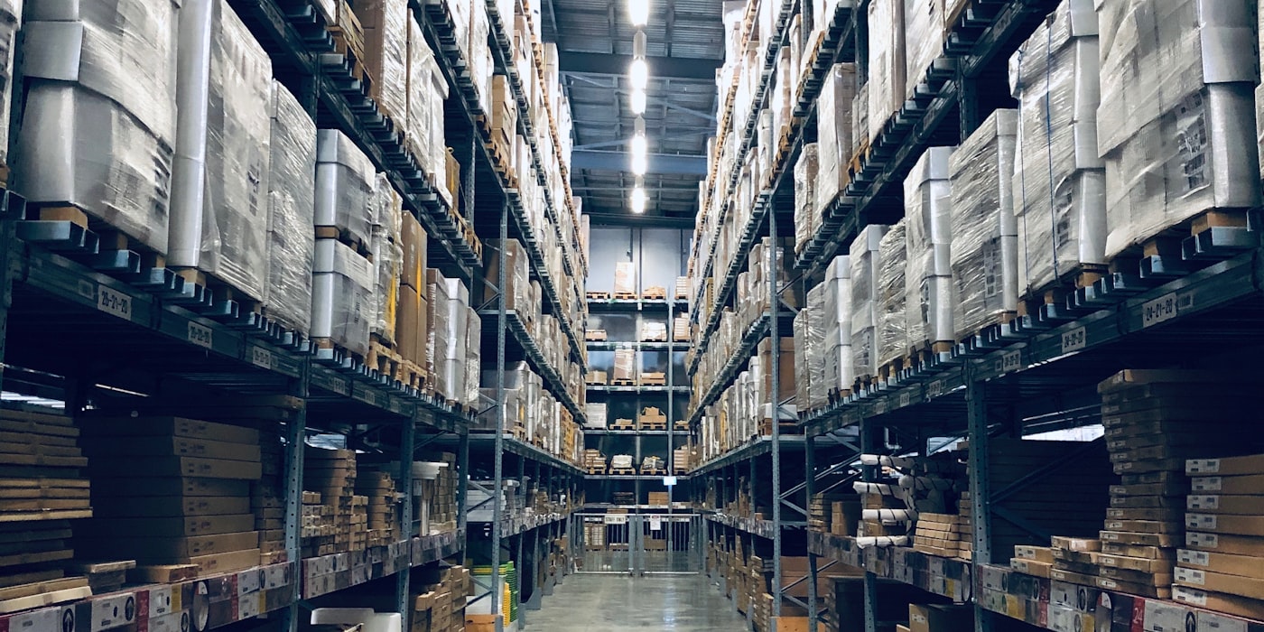 Pasillo de CEDIS con racks y tarimas: trazabilidad logística del viaje