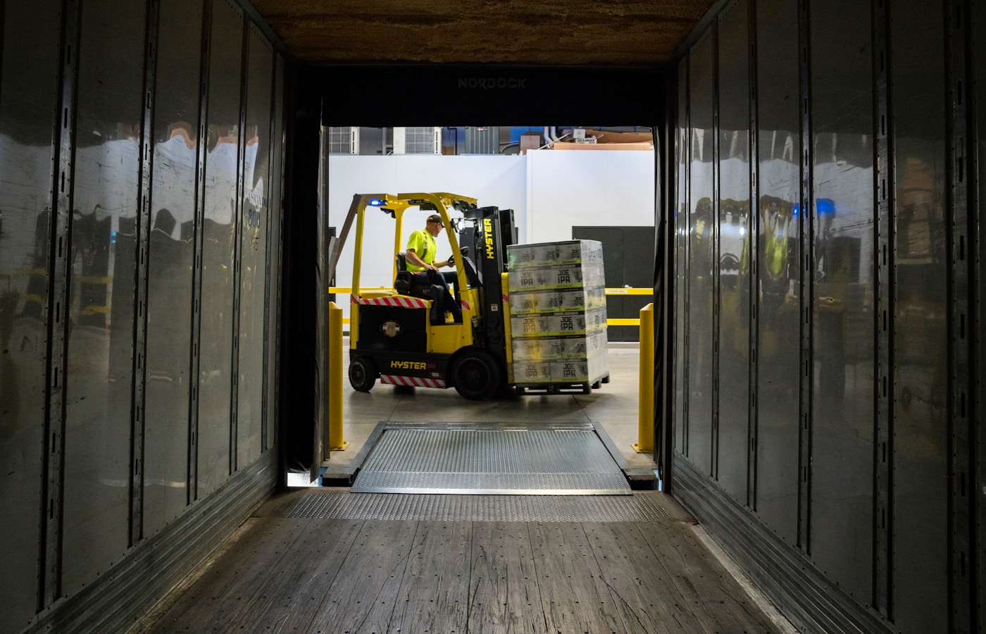 CEDIS dock with forklift loading a stretch-wrapped pallet: packing ready for outbound freight