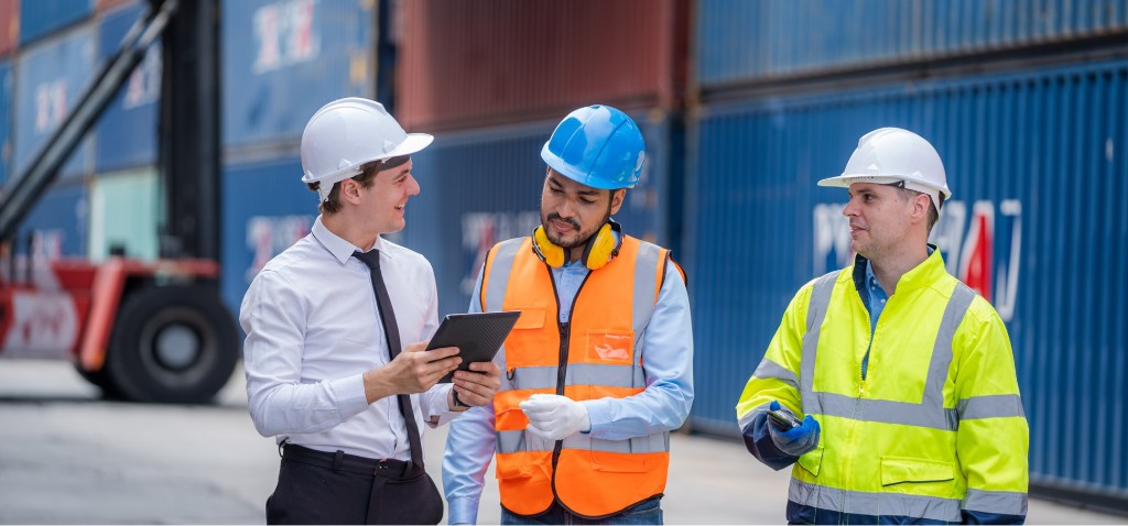 Equipo de patio coordinando asignación con tablet en terminal de contenedores